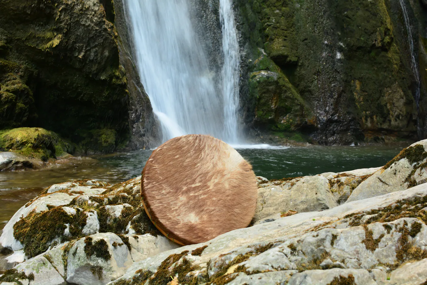Tambour posé près d’une cascade en forêt